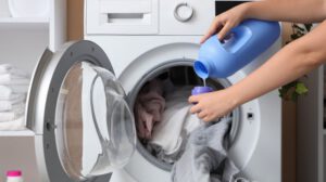 Lençol de malha 100% algodão sendo colocado na máquina de lavar no ciclo delicado.