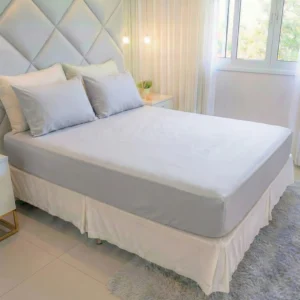Jogo de lençol queen 400 fios cinza claro ambientado em cama de casal tamanho queen em quarto sofisticado.